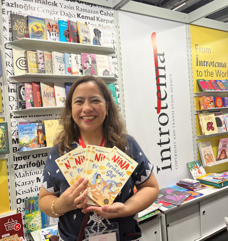 An international publisher holding books represented by Introtema at the Frankfurt Book Fair 2025.
