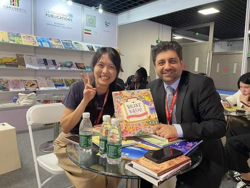 Introtema Agency Co-Founder Muhammed Ağırakça holding Brave Katie book with publisher at Beijing International Book Fair.