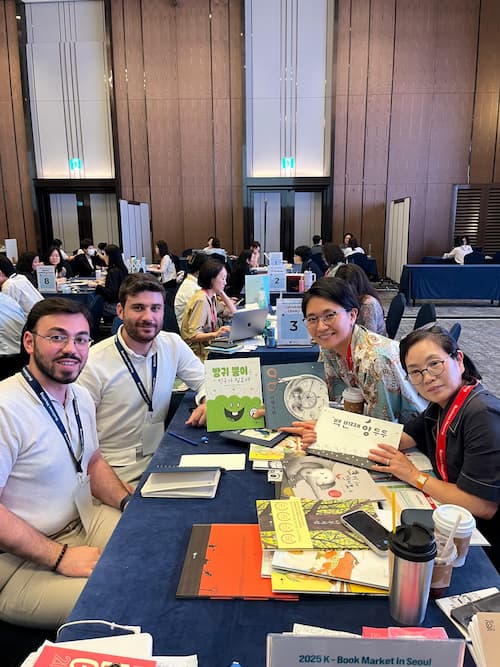 Introtema Agency team meeting Korean literary partners at Seoul International Book Fair table.